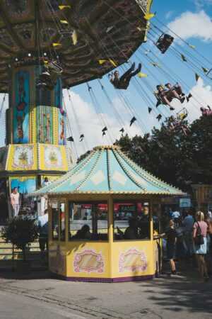 a carnival with a carousel and flying birds